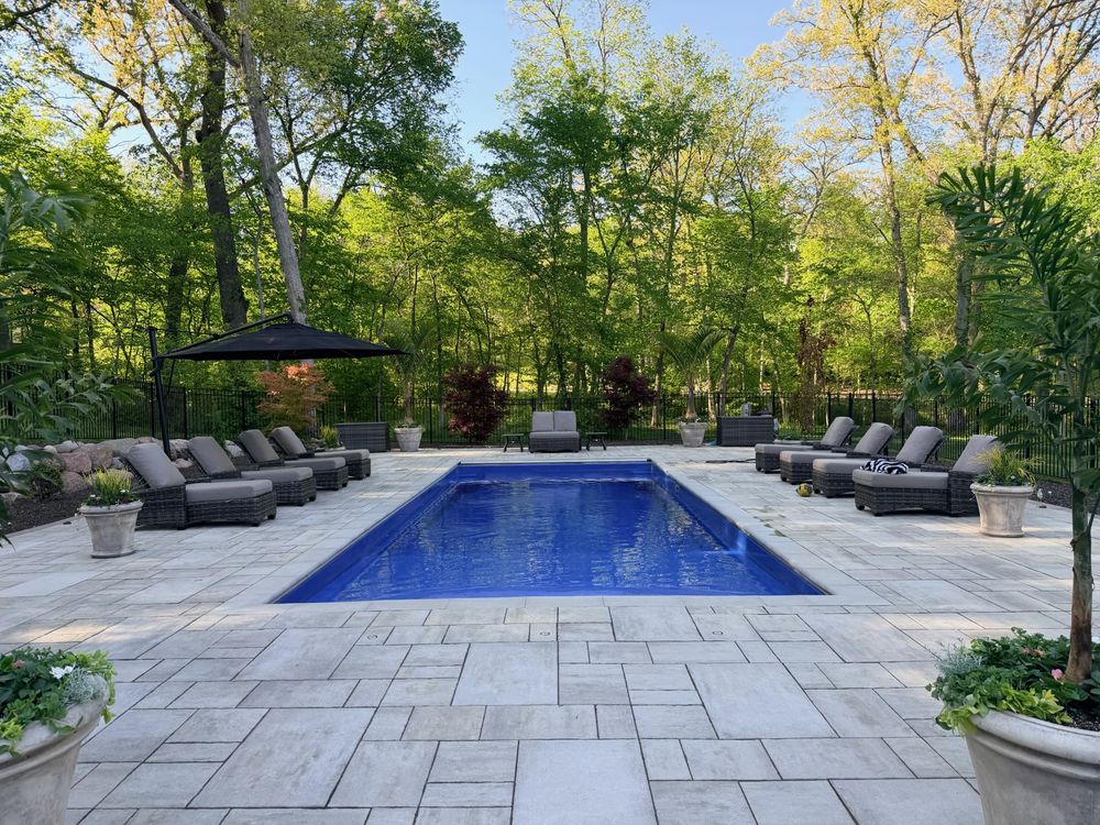 inground pool surrounded by stone patio in the daytime